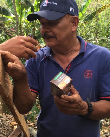 Doselva farmer looking at the Gaia Turmeric Supreme capsules made with turmeric he supplied.